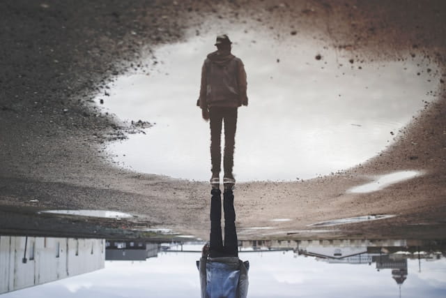 man's reflection on body of water photography Photo by Randy Jacob on Unsplash